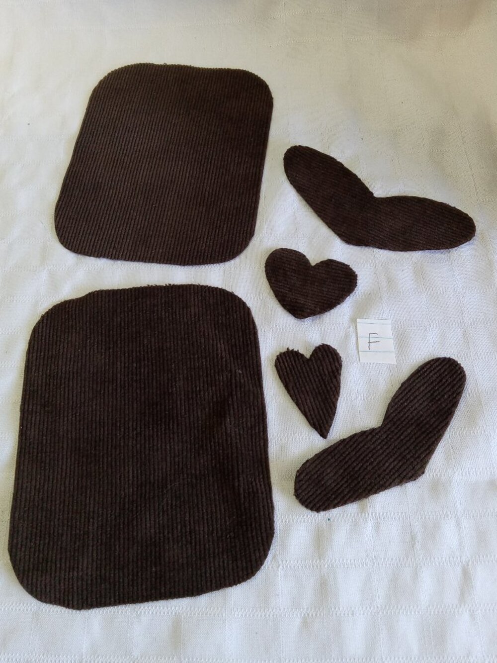 Two handmade elbow patches for sewing made of brown corduroy with hearts